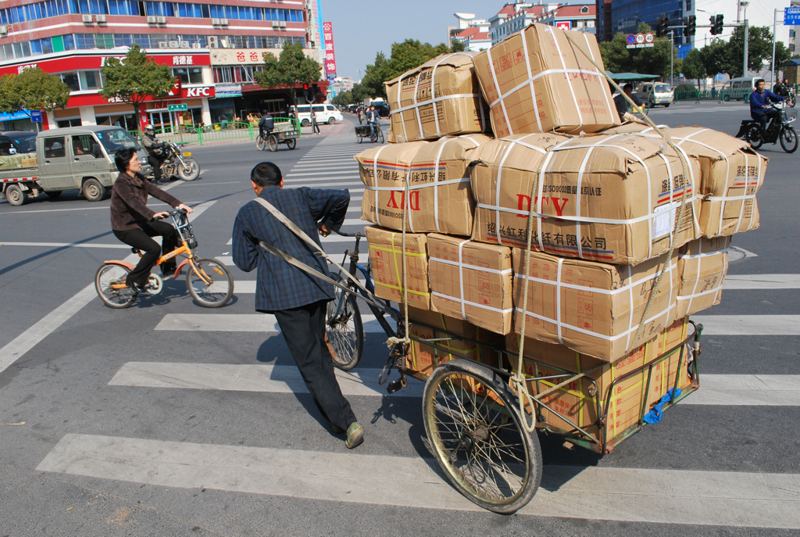 Triciclo carregado de caixas nas ruas de Yiwu